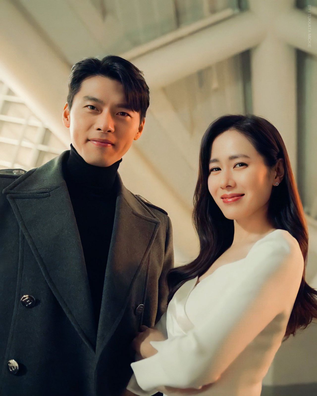 Ở đây, Hyun Bin chọn diện áo cổ lọ kết hợp áo khoác dạ. Trong khi đó, Son Ye Jin thì diện thiết kế váy trắng dài tay với kiểu cổ vắt chéo