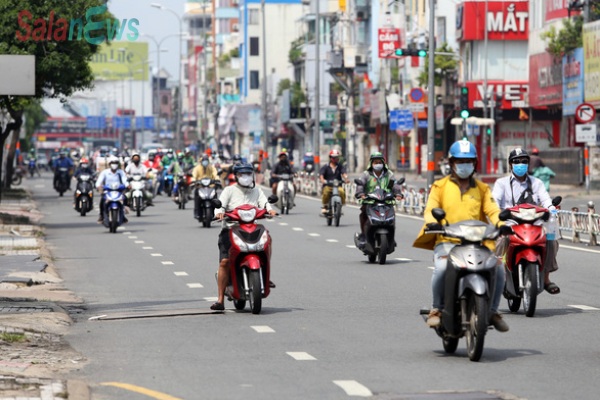 Gần trưa, đường phố TP.HCM vẫn đông người đi lại